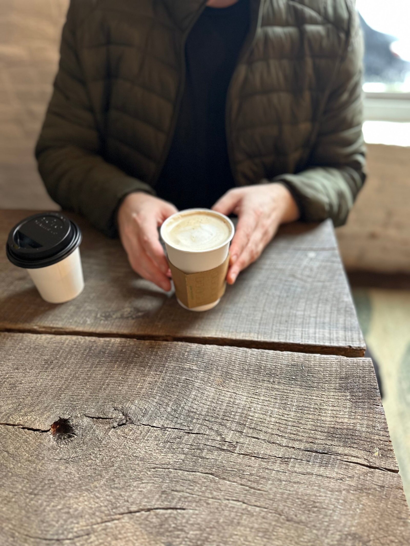 Eurasia Coffee Co Brew Downtown Seated holding House Coffee Blend at Eurasia Cafe in Downtown Springfield, MO